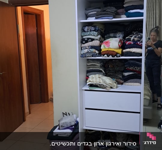 ארון בגדים לבן עם מדפים מלאים בבגדים מקופלים